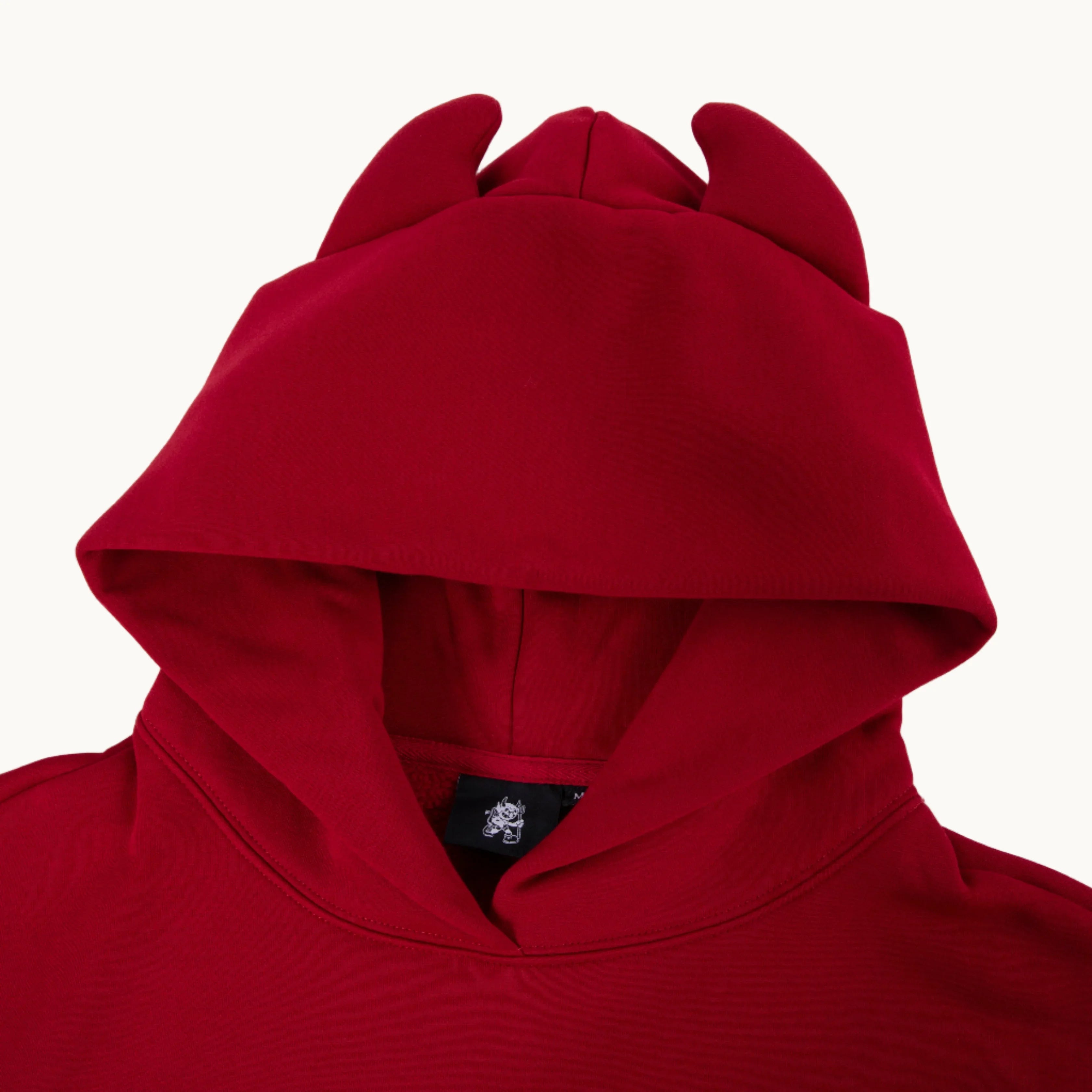 Red hoodie with devil horns on hood, streetwear clothing against white background