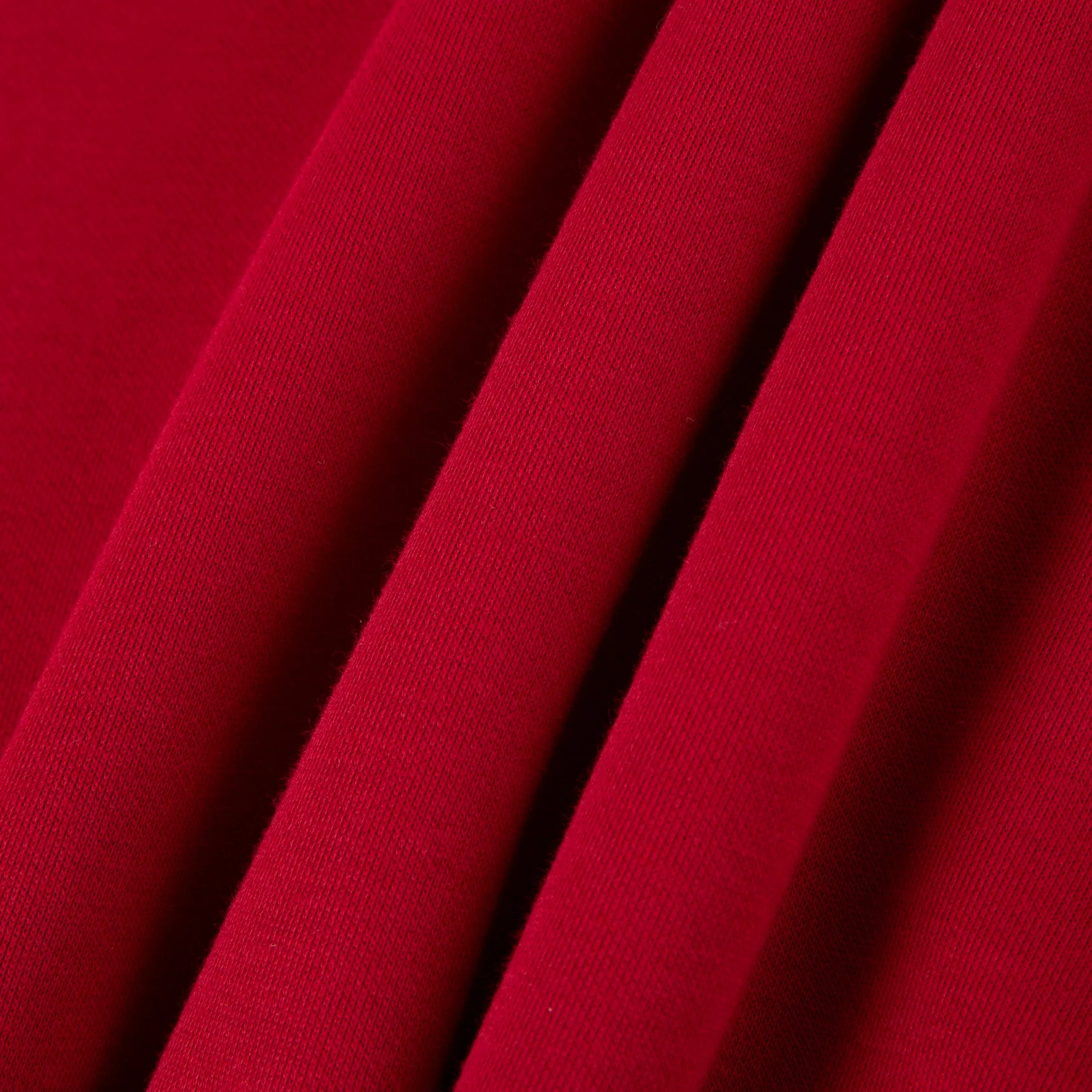 close-up of folded red cotton fabric texture, textile material detail